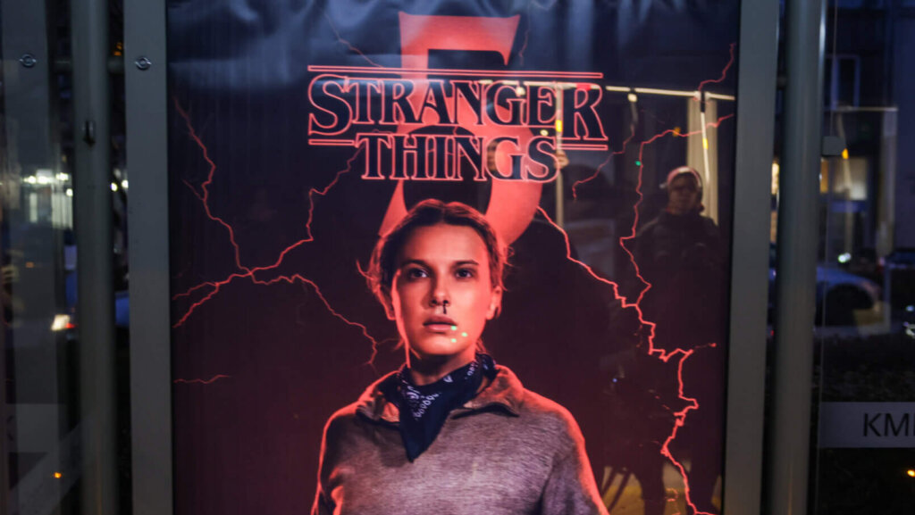 Stranger Things Season 5 poster featuring Eleven with a nosebleed and lightning effects at a bus stop at night