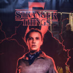 Stranger Things Season 5 poster featuring Eleven with a nosebleed and lightning effects at a bus stop at night