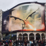 Large HBO Max billboard in a city showing a dragon breathing fire from the series House of the Dragon