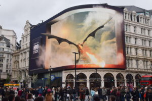 Large HBO Max billboard in a city showing a dragon breathing fire from the series House of the Dragon