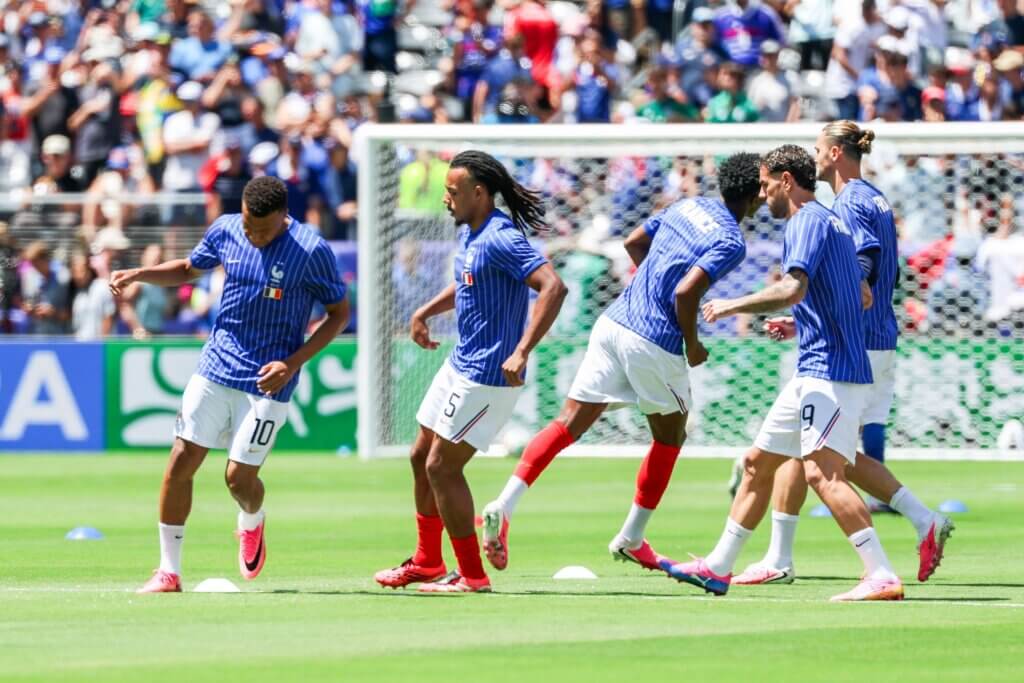 French national soccer team players warming up on the field before a match