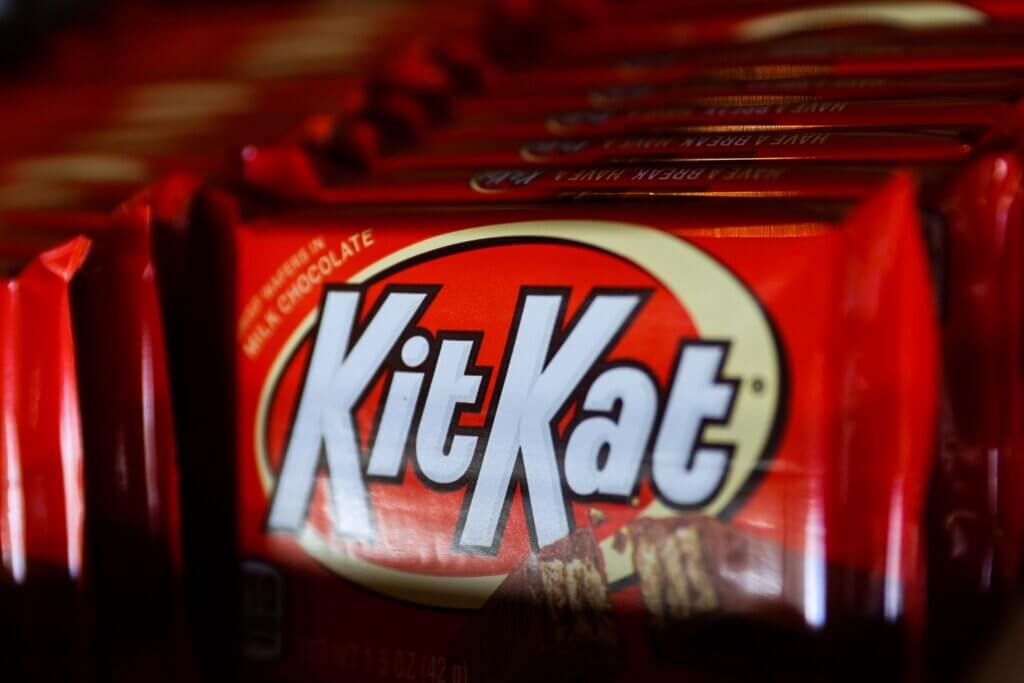 Close-up of Kit Kat chocolate bars in red packaging stacked in a row