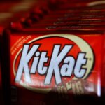 Close-up of Kit Kat chocolate bars in red packaging stacked in a row