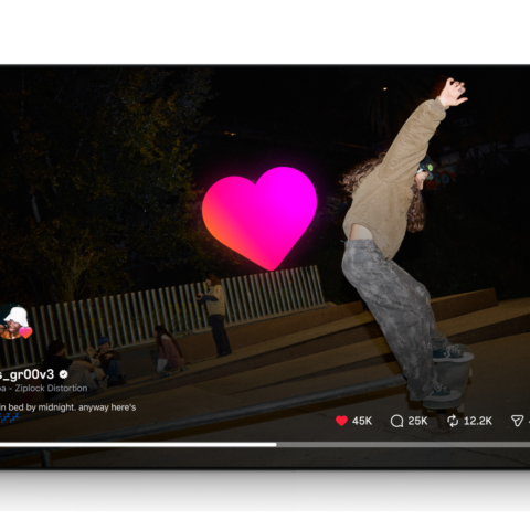 Skateboarder stellas_gr00v3 performing a kickflip at night in a skatepark with spectators in the background.