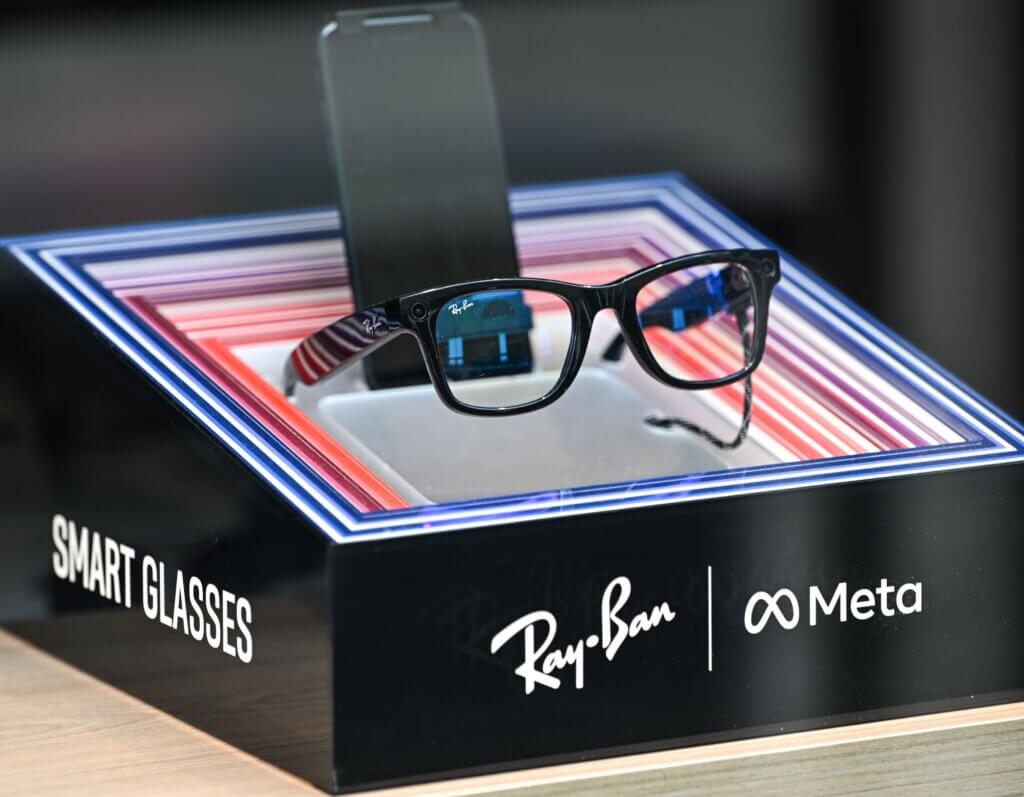 Ray-Ban smart glasses displayed on a stand with Meta branding and colorful LED frame accents.