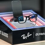 Ray-Ban smart glasses displayed on a stand with Meta branding and colorful LED frame accents.