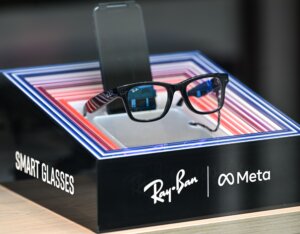 Ray-Ban smart glasses displayed on a stand with Meta branding and colorful LED frame accents.
