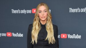 Blonde woman in black suit posing on red carpet at YouTube event with "There's only one YouTube" backdrop